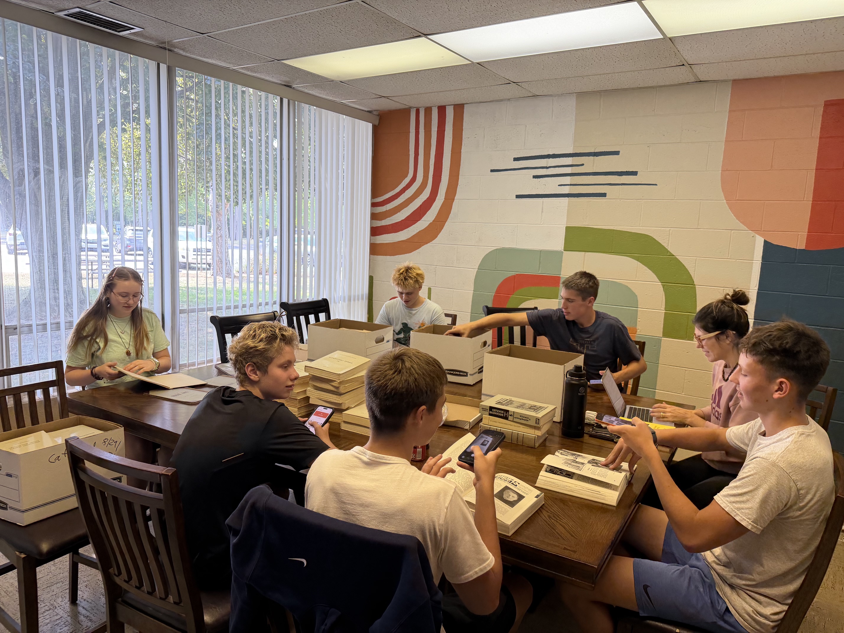 Young people cataloging Lithuanian books together at a table